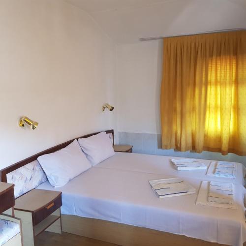 a bedroom with a large white bed with a window at Slantse in Sozopol