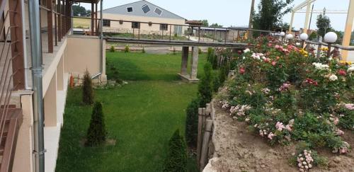 a view of a garden with flowers and a building at Seven Generations Winery Hotel in Mechka