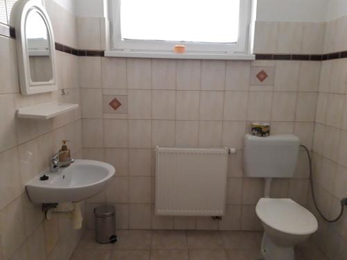 a bathroom with a sink and a toilet and a window at TIC Hervartov in Hervartov