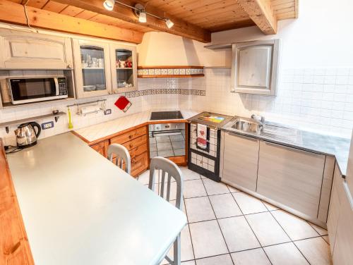 a kitchen with a table and a counter top at Appartamento Casa Brigadoi in Predazzo