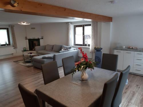 ein Wohnzimmer mit einem Tisch und einem Sofa in der Unterkunft Familienfreundliche Ferienwohnung in Zschorlau