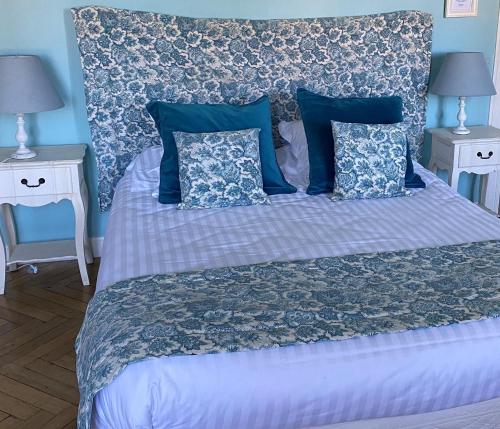 1 dormitorio con 1 cama con almohadas azules en Le Gite des Jardins de Mazamet, en Mazamet