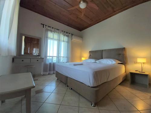 a bedroom with a large bed and a window at Liogerma Apartments in Tsoukaladhes