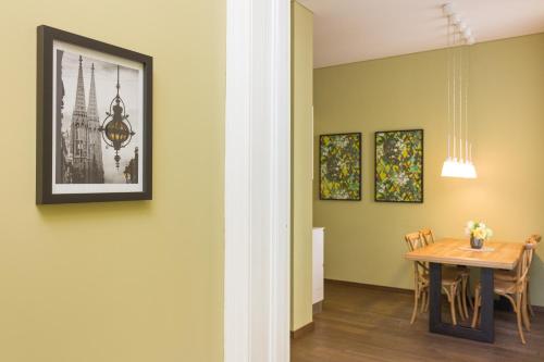 a dining room with a table and a picture on the wall at RAFAEL KAISER - Premium Apartments - Contactless Check-In in Vienna
