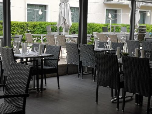 una fila de mesas y sillas en un restaurante en Hotel du Commerce, en Châtillon-sur-Chalaronne