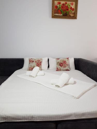 a white bed with two pillows and a picture on the wall at RELAX ALEZZI BEACH RESORT in Mamaia Nord