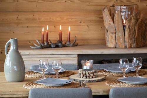 una mesa con velas, platos y copas de vino en Residence Miravidi La Rosiere, en La Rosière