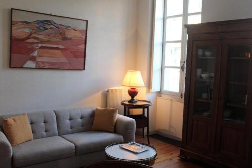 sala de estar con sofá y lámpara en Burdigala Homes - Appart Sainte Catherine, en Burdeos