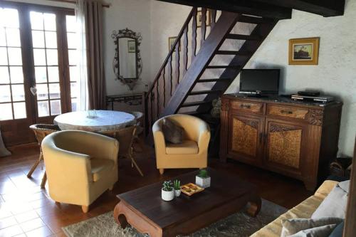 アピエットにあるDemi villa à 150m de la plage avec vue sur merのリビングルーム(階段、椅子、テーブル付)