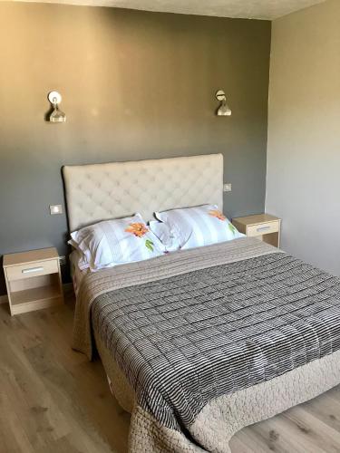 une chambre avec un grand lit avec deux tables de nuit dans l'établissement Villa Solsticia, à Porticcio