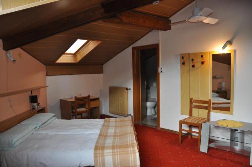um quarto com uma cama grande e uma casa de banho em Hotel Residence Rosa em San Lugano