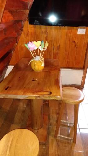 a wooden table with a vase of flowers on it at Chalé - Sossego 1 in Campos do Jordão