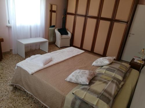 a bedroom with a large bed with two pillows on it at LA COQUILLE appartamento vicino all'ospedale in Negrar