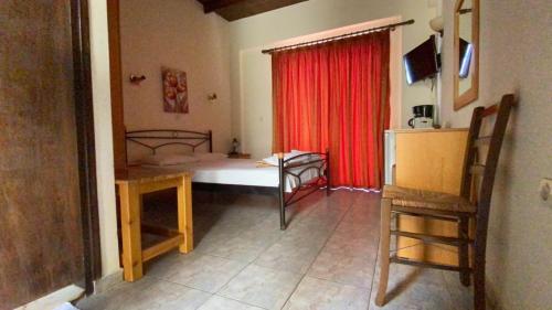 a room with a bed and a red curtain at Apanemia Rooms in Triopetra