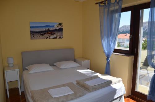 a bedroom with a bed with towels on it at Apartments Aneva in Baška