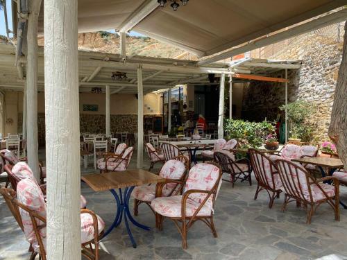 a patio with chairs and tables and tables and a building at Apanemia Rooms in Triopetra