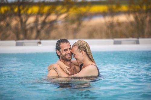 a man and woman in a swimming pool at Fjordgaarden - Spa - Hotel - Konference in Ringkøbing