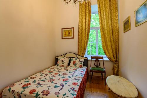 a bedroom with a bed and a chair and a window at Admirala nams in Liepāja