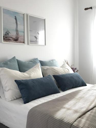 a white bed with blue pillows in a bedroom at Volta Superior Studios in Avlemonas