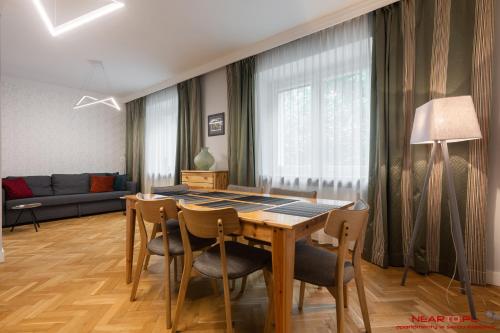a living room with a table and chairs and a couch at Apartment Nearto Old Town Daszyńskiego street in Krakow