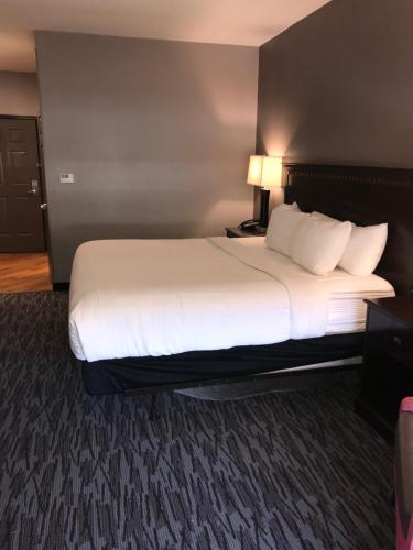 a bedroom with a large bed with white sheets and pillows at La Quinta by Wyndham Abilene Mall in Abilene