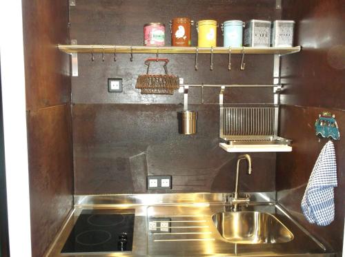 Il comprend une cuisine équipée d'un évier en acier inoxydable et d'une cuisinière. dans l'établissement Appartement Résidence Astoria, à Chamonix-Mont-Blanc