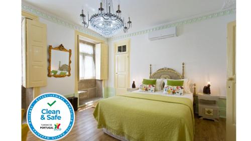 a bedroom with a green bed and a chandelier at HC Villa Douro in Vila Nova de Gaia