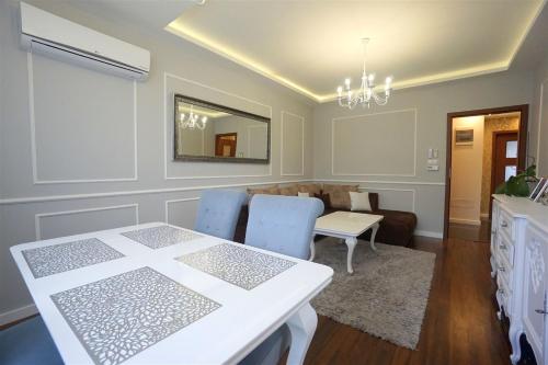 a dining room with a white table and blue chairs at Apartament Rymanowska in Rzeszów