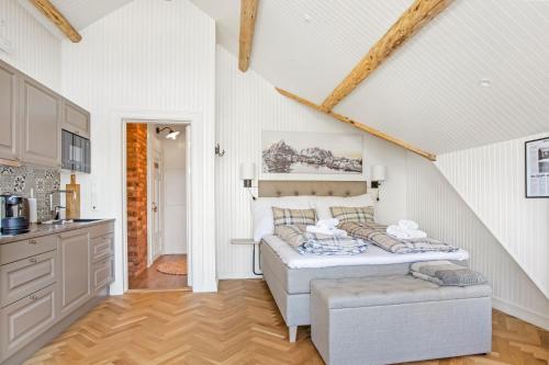 a bedroom with a bed in a room with a kitchen at Sakrisøy Gjestegård - Manor House in Sakrisøy - Solbakken anno 1880 in Reine