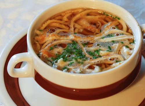 a cup of soup with noodles on a plate at Gästehaus Watschinger in Bad Wimsbach-Neydharting