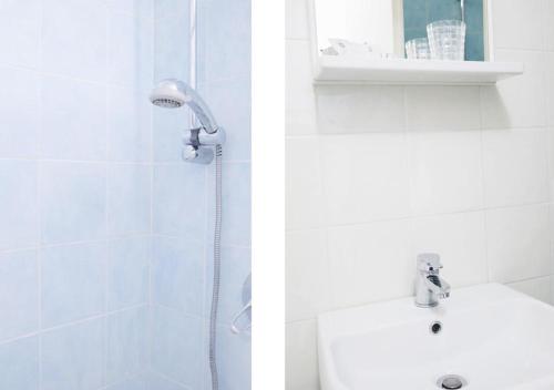a white bathroom with a shower and a sink at Viadeibanchi in Riomaggiore