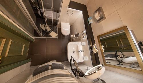 a bathroom with a sink and a toilet and a mirror at Parkhotel Plauen in Plauen