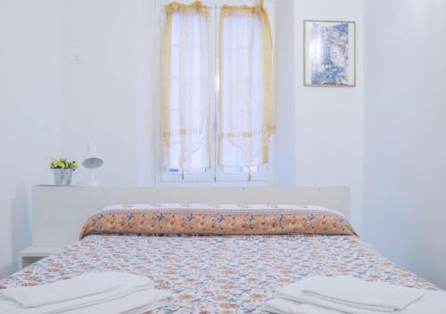 a bed in a white room with a window at Viadeibanchi in Riomaggiore
