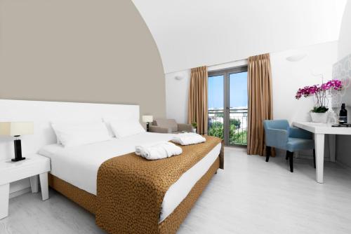 a white bedroom with a bed and a desk and a window at Ruth Daniel Residence in Tel Aviv