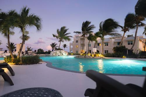 a swimming pool with palm trees in front of a building at Northwest Point Resort in Wheeland Settlement