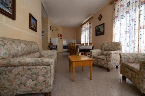 a living room with couches and chairs and a table at Sunset Seaview Apartments in Marsalforn