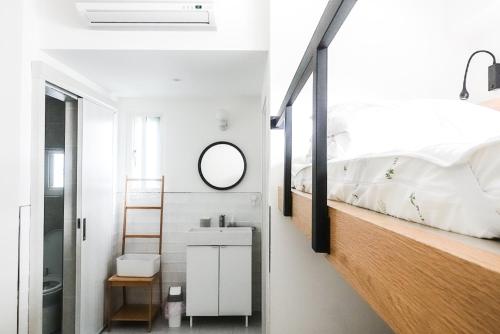 Schlafzimmer mit einem Bett, einem Waschbecken und einem Spiegel in der Unterkunft Ren Homestay in Altstadt von Hengchun