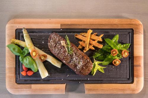 a plate of food with a steak and french fries at Parkhotel Plauen in Plauen