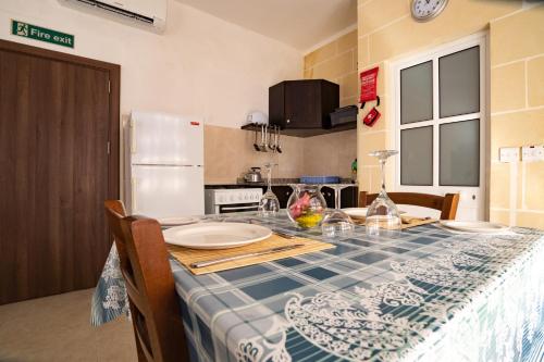a kitchen with a table with a blue and white at Sunset Seaview Apartments in Marsalforn