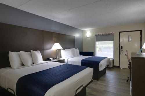 a hotel room with two beds and a window at Baymont by Wyndham Ridgeland I-95 in Ridgeland