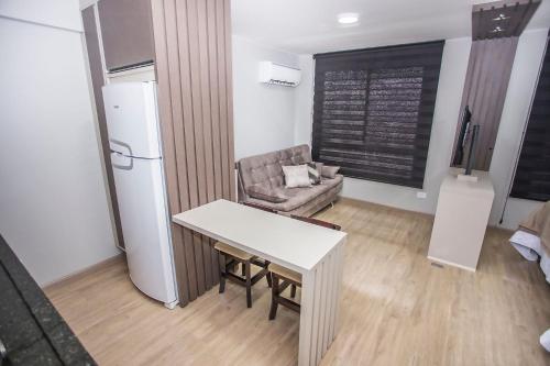 een keuken met een tafel en een bank in een kamer bij Studio com Cama e Sofá-Cama de Casal - ALL2011 in Curitiba