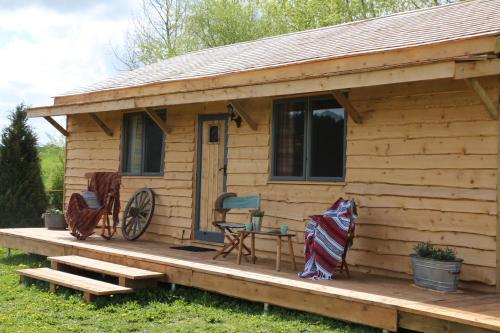 a wooden cabin with a bench and a table and chairs at Wranglers Den in Bilsthorpe