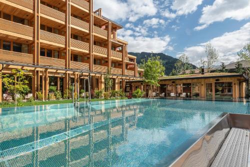 an empty swimming pool in front of a building at MalisGarten Green Spa Hotel in Zell am Ziller