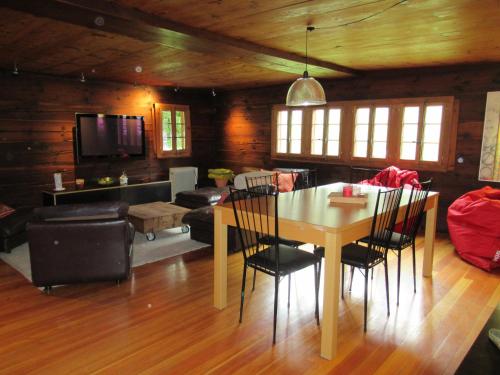 a dining room and living room with a table and chairs at Chalet historique de haut standing in La Tour