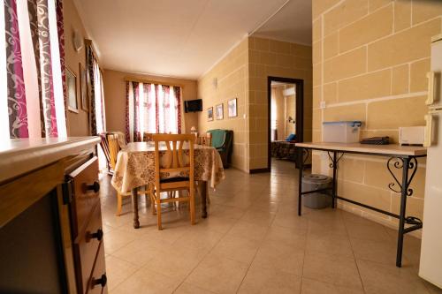 a kitchen and dining room with a table and chairs at Sunset Seaview Apartments in Marsalforn