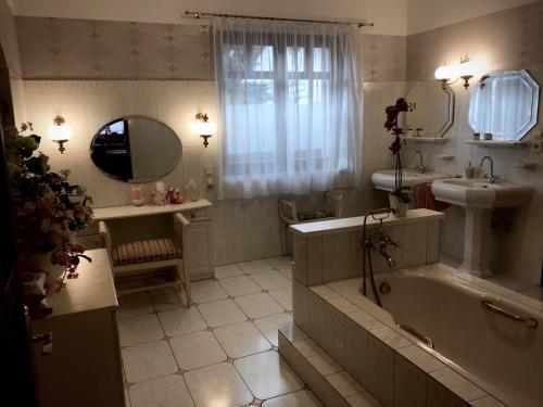 a bathroom with a tub and a sink and a mirror at Mercedes Garden in Budapest