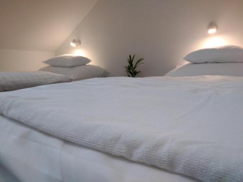 a bedroom with two white beds with pillows at Diana Panzió in Mátrafüred