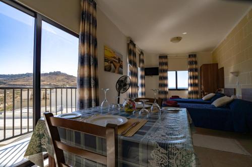 sala de estar con mesa y vistas en Sunset Seaview Apartments, en Marsalforn