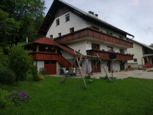 une grande maison blanche avec un toit en gambrel dans l'établissement Apartmaji Pika, à Cerklje na Gorenjskem