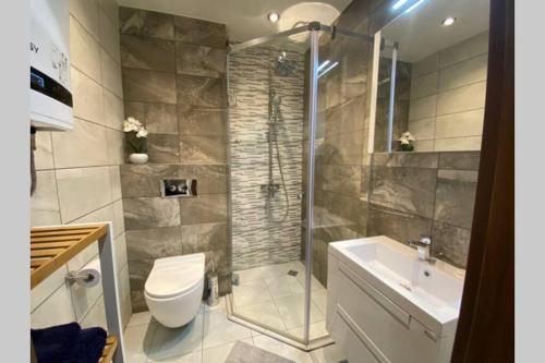 a bathroom with a shower and a toilet and a sink at Studio 13 in Varna City